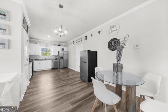 kitchen with dark wood finished floors, ornamental molding, backsplash, and appliances with stainless steel finishes