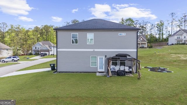 back of house featuring a lawn and a gazebo