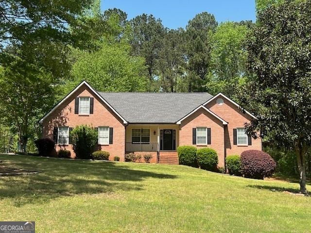 ranch-style house featuring brick siding, a front lawn, and covered porch