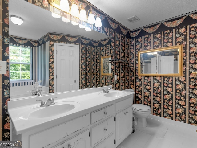 75 The Farm Rd, Mcdonough, GA 30252 - full bathroom with double vanity, a textured ceiling, wallpapered walls, toilet, and tile patterned flooring