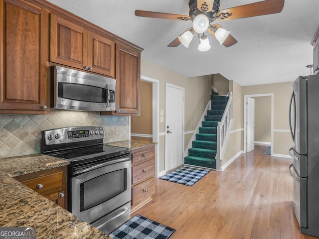 75 The Farm Rd, Mcdonough, GA 30252 - kitchen with stainless steel appliances, a ceiling fan, backsplash, baseboards, and a textured ceiling