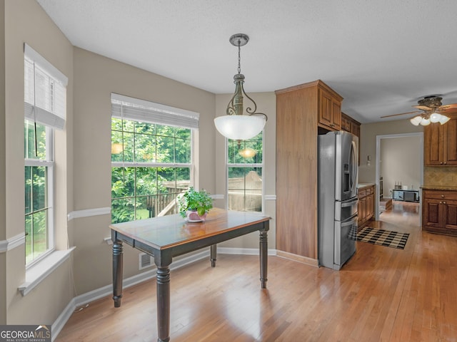 75 The Farm Rd, Mcdonough, GA 30252 - kitchen with stainless steel fridge with ice dispenser, light wood-style floors, plenty of natural light, and brown cabinetry