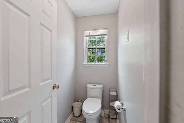 bathroom featuring baseboards and toilet