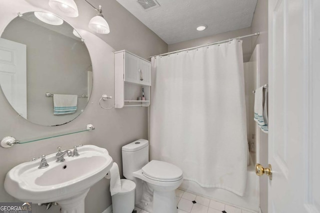 full bath featuring tile patterned floors, a textured ceiling, toilet, visible vents, and a sink