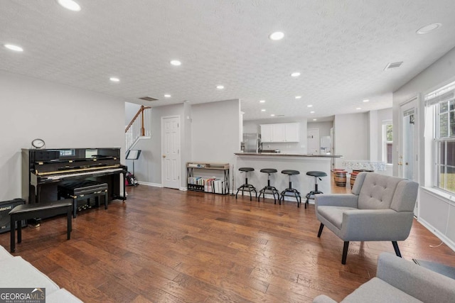 interior space with a textured ceiling, visible vents, recessed lighting, wood-type flooring, and baseboards