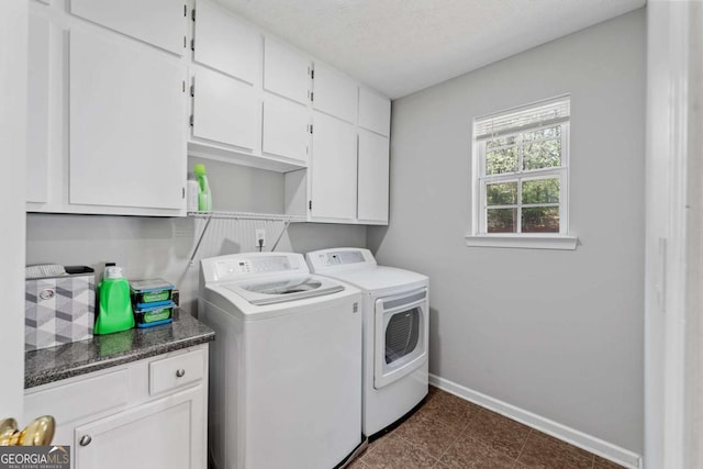 laundry area with cabinet space, baseboards, washing machine and dryer, and a textured ceiling