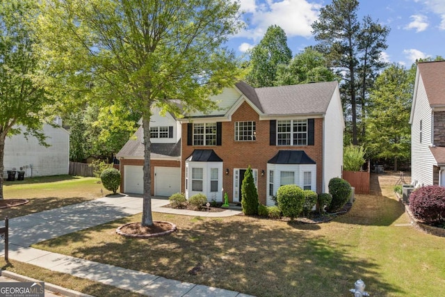colonial-style house featuring concrete driveway, a front lawn, an attached garage, brick siding, and fence