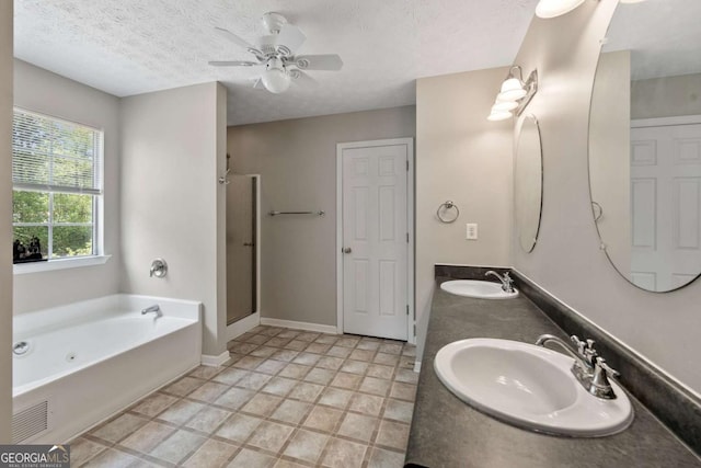 bathroom with a sink, a whirlpool tub, a shower stall, and a textured ceiling