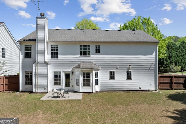 rear view of property featuring a patio area, fence, and a lawn