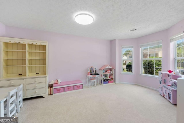 playroom with carpet flooring, visible vents, a textured ceiling, and baseboards