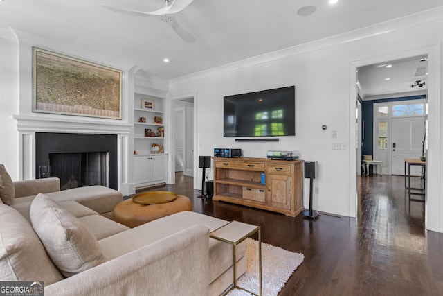 1116 Dan Johnson Rd NE, Atlanta, GA 30307 - living room featuring built in shelves, crown molding, dark wood-style floors, a ceiling fan, and baseboards