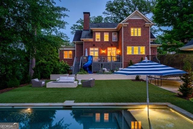 1116 Dan Johnson Rd NE, Atlanta, GA 30307 - rear view of property featuring stairs, brick siding, an outdoor pool, an outdoor living space, and a chimney