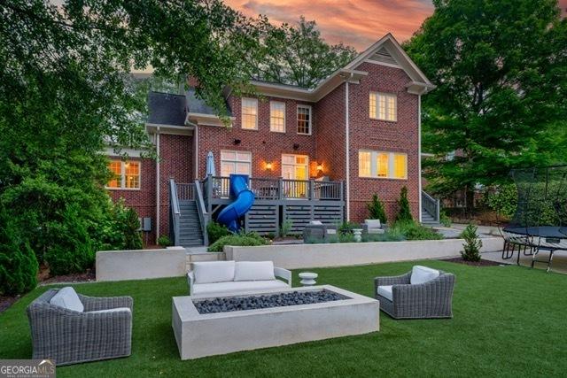 1116 Dan Johnson Rd NE, Atlanta, GA 30307 - back of property with a yard, stairs, an outdoor living space with a fire pit, and a trampoline