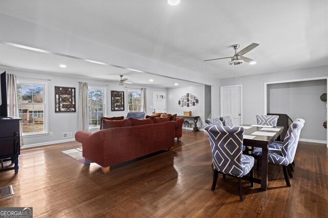living area featuring baseboards, a ceiling fan, and visible vents
