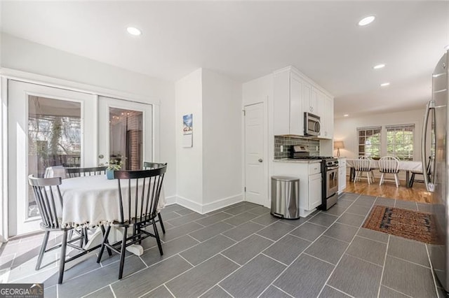 1884 Montrose Dr, East Point, GA 30344 - kitchen featuring decorative backsplash, white cabinets, baseboards, appliances with stainless steel finishes, and recessed lighting