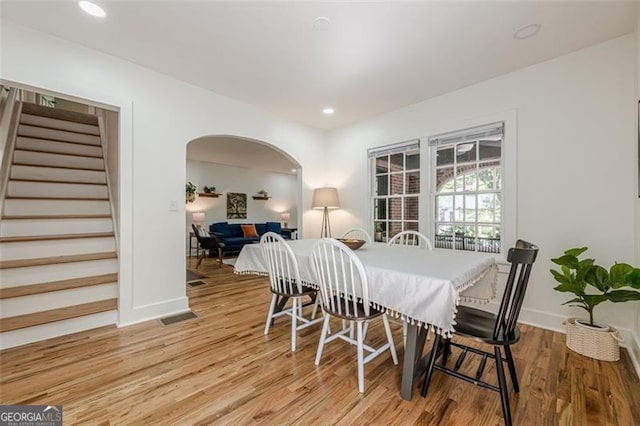 1884 Montrose Dr, East Point, GA 30344 - dining room with stairway, light wood-type flooring, arched walkways, baseboards, and visible vents