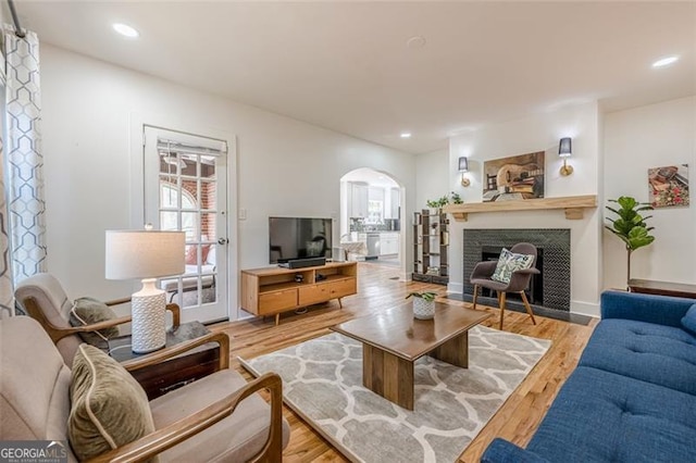 1884 Montrose Dr, East Point, GA 30344 - living room with arched walkways, a fireplace with flush hearth, light wood-type flooring, and recessed lighting