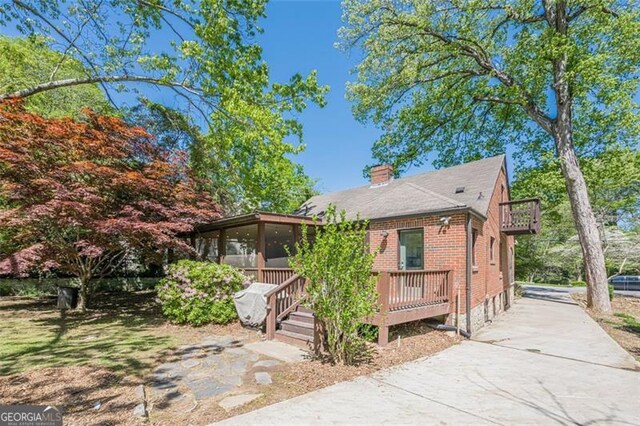 1884 Montrose Dr, East Point, GA 30344 - view of front of house with a chimney, a sunroom, brick siding, and a deck