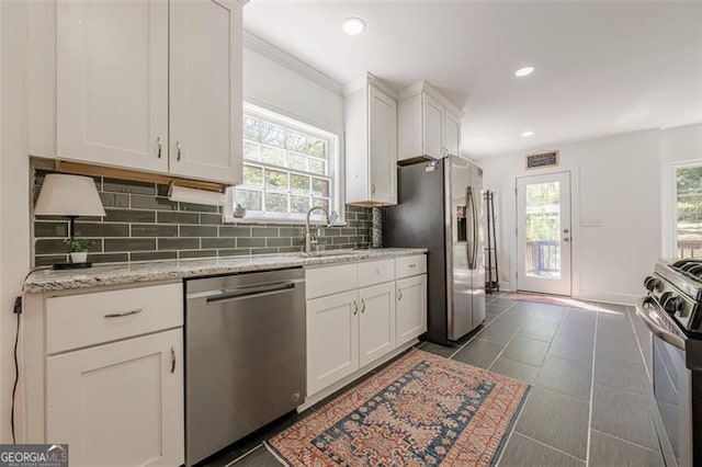 1884 Montrose Dr, East Point, GA 30344 - kitchen featuring white cabinets, stainless steel appliances, a sink, tasteful backsplash, and light stone countertops