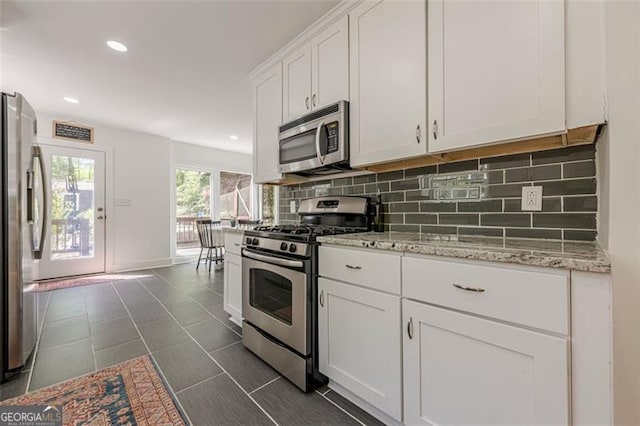 1884 Montrose Dr, East Point, GA 30344 - kitchen featuring recessed lighting, white cabinets, light stone counters, backsplash, and appliances with stainless steel finishes