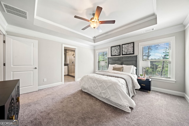 bedroom with a tray ceiling, light carpet, baseboards, and visible vents