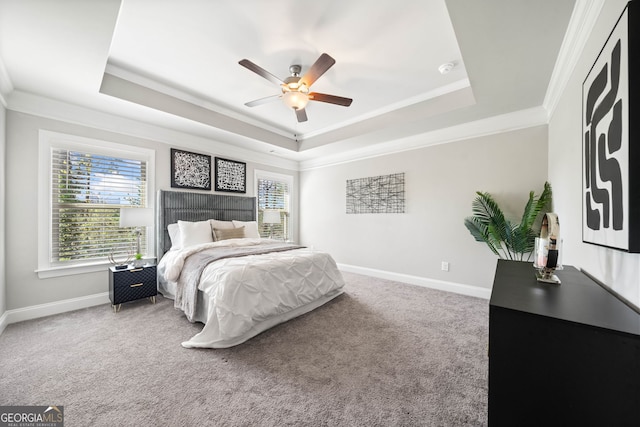 bedroom featuring a raised ceiling, carpet flooring, baseboards, and multiple windows