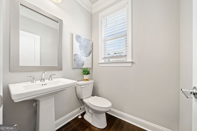 bathroom with toilet, baseboards, and wood finished floors