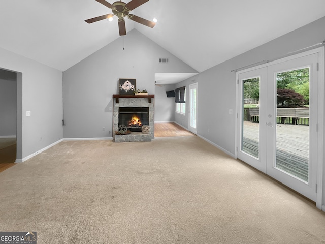 unfurnished living room featuring a fireplace, a ceiling fan, visible vents, carpet flooring, and french doors