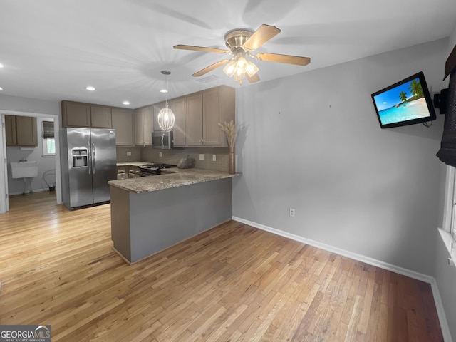 kitchen with tasteful backsplash, light wood-type flooring, a peninsula, a ceiling fan, and stainless steel appliances