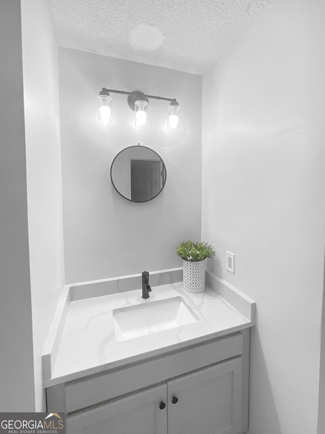 bathroom featuring a textured ceiling and vanity