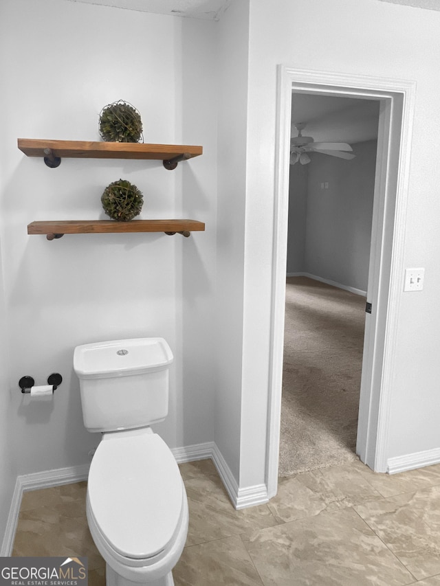 bathroom with baseboards, toilet, and ceiling fan