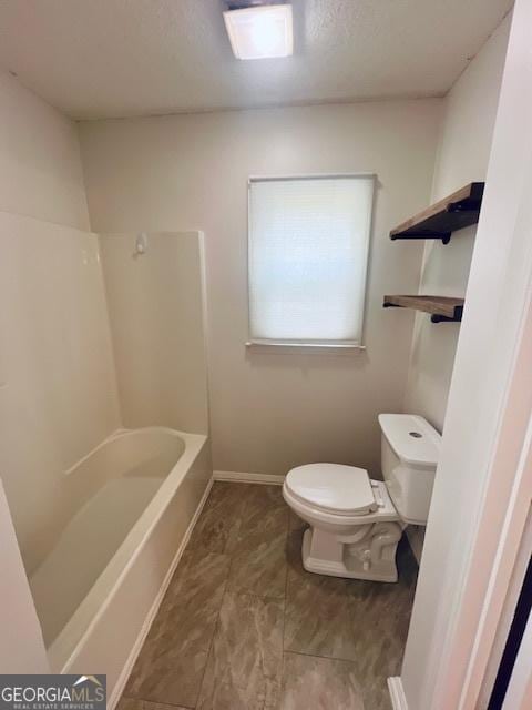 full bathroom with shower / bathtub combination, baseboards, a textured ceiling, and toilet