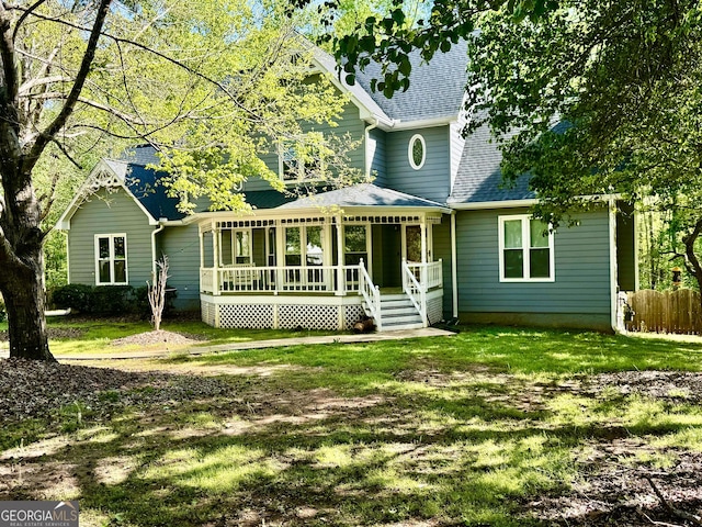 rear view of property with a yard, a shingled roof, and a wooden deck