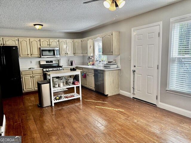 kitchen featuring dark wood-style flooring, light countertops, a wealth of natural light, ceiling fan, and appliances with stainless steel finishes