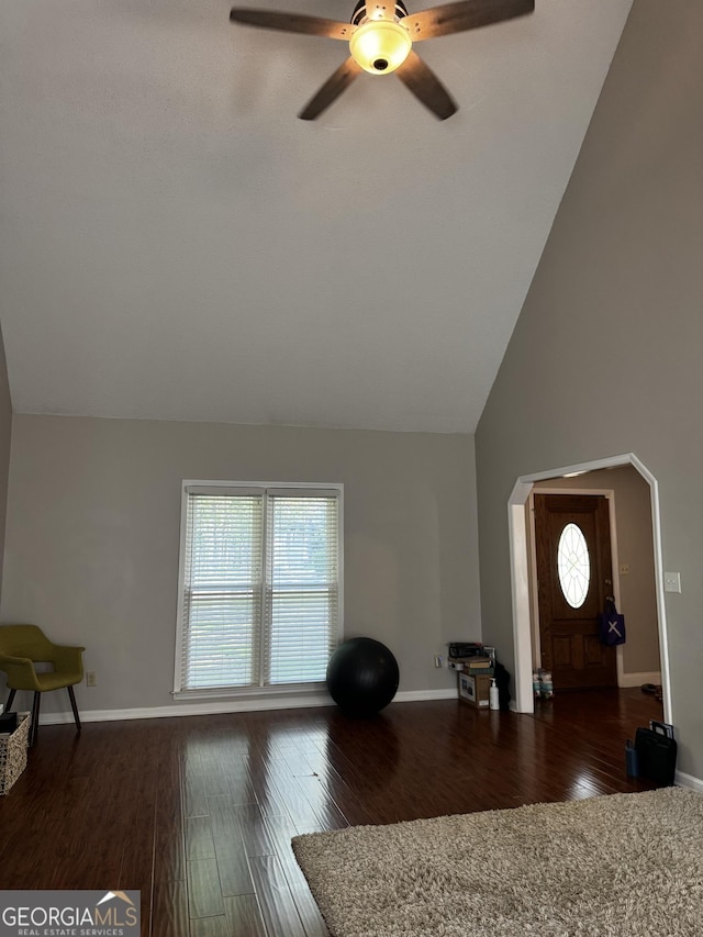 living area with wood finished floors, baseboards, a ceiling fan, and a healthy amount of sunlight