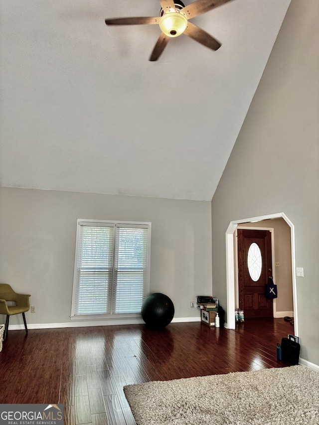 living room with high vaulted ceiling, baseboards, wood finished floors, and ceiling fan
