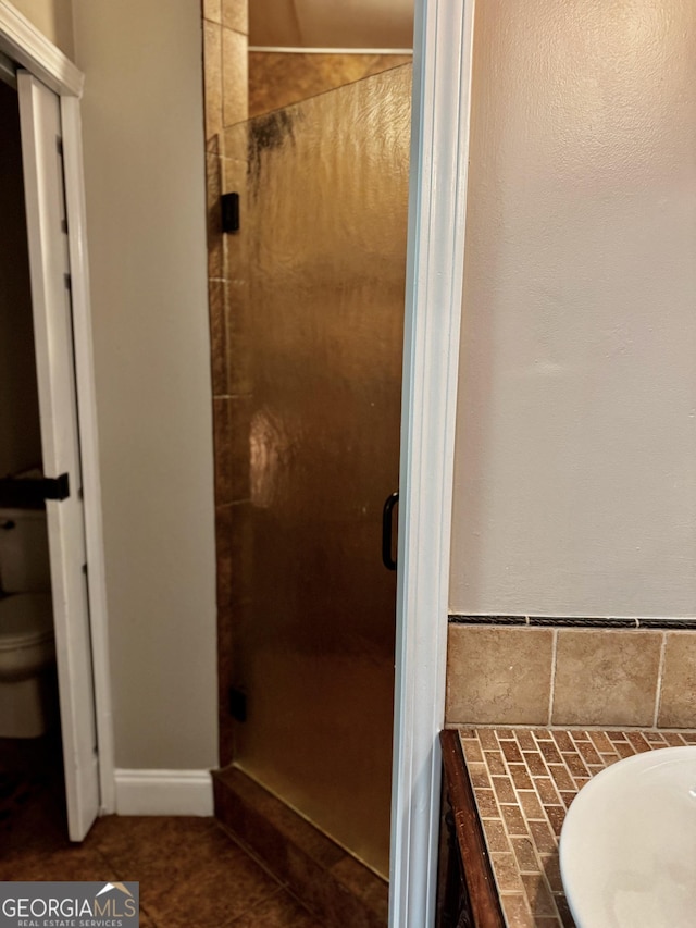 full bath featuring a shower stall and toilet