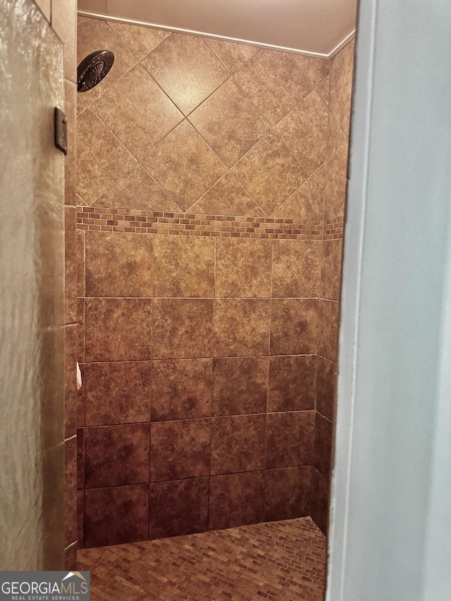 interior details featuring a tile shower