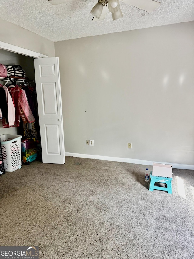 bedroom featuring a closet, baseboards, a ceiling fan, carpet, and a textured ceiling