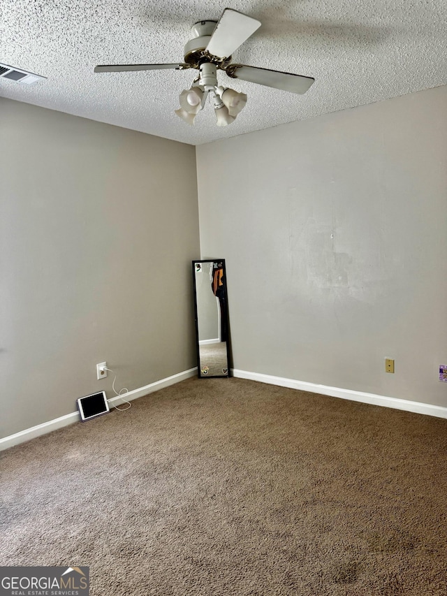 carpeted spare room featuring visible vents, ceiling fan, baseboards, and a textured ceiling