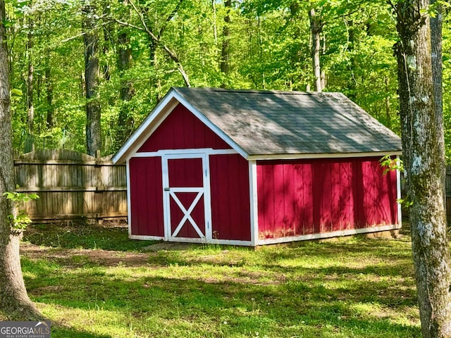 view of outdoor structure featuring an outbuilding and fence