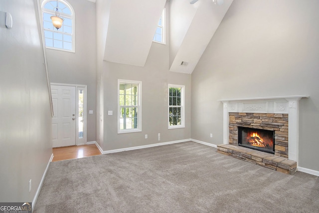 432 Tanner Farm Dr, Rockmart, GA 30153 - unfurnished living room with a towering ceiling, carpet, a stone fireplace, healthy amount of natural light, and baseboards