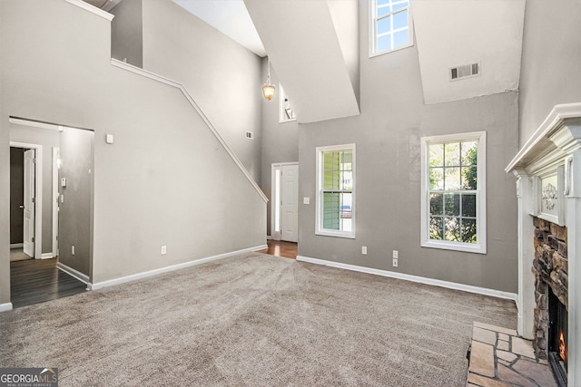 432 Tanner Farm Dr, Rockmart, GA 30153 - unfurnished living room featuring a fireplace, a towering ceiling, carpet flooring, baseboards, and stairs