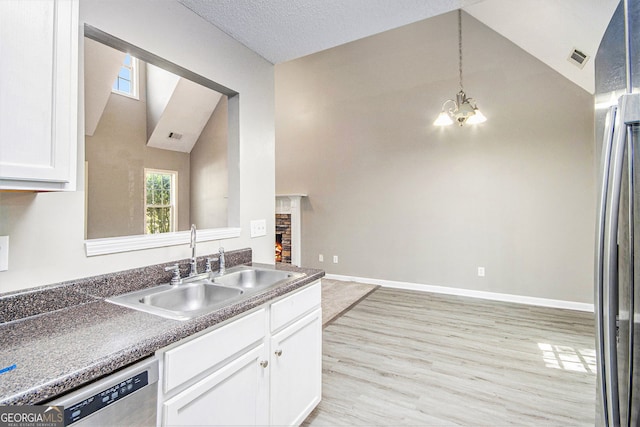 432 Tanner Farm Dr, Rockmart, GA 30153 - kitchen with a sink, appliances with stainless steel finishes, white cabinetry, light wood-type flooring, and a chandelier