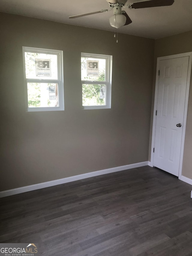 576 Pansy Ave, Macon, GA 31204 - empty room with dark wood finished floors, a healthy amount of sunlight, baseboards, and a ceiling fan