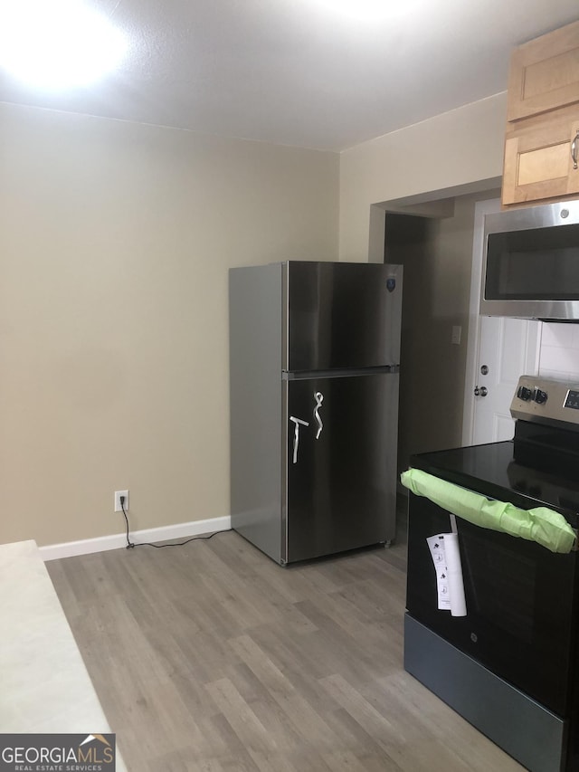 576 Pansy Ave, Macon, GA 31204 - kitchen with light brown cabinets, light wood finished floors, baseboards, and stainless steel appliances