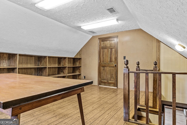 3588 SW Highridge Dr, Conyers, GA 30094 - additional living space with wooden walls, a textured ceiling, visible vents, hardwood / wood-style floors, and lofted ceiling