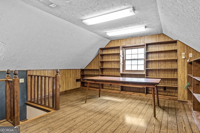 3588 SW Highridge Dr, Conyers, GA 30094 - additional living space featuring hardwood / wood-style floors, wooden walls, vaulted ceiling, and a textured ceiling