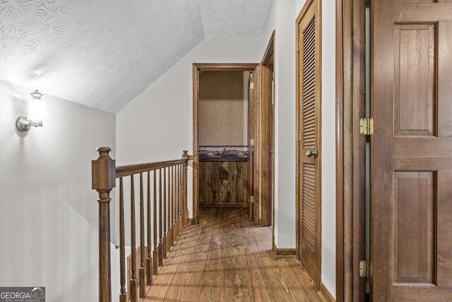 3588 SW Highridge Dr, Conyers, GA 30094 - hallway with an upstairs landing, hardwood / wood-style flooring, a textured ceiling, and lofted ceiling