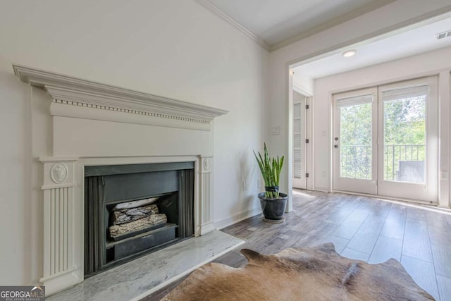 3203 Lenox Rd NE Unit 32, Atlanta, GA 30324 - unfurnished living room featuring crown molding, a fireplace with raised hearth, wood finished floors, and baseboards